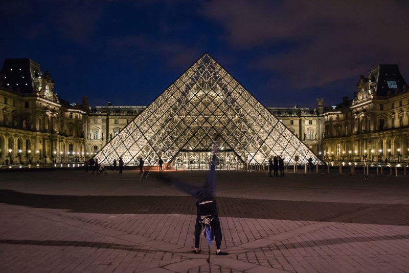 What to see at the Louvre in 2 hours includes the pyramid entrances lit up at night in front of the museum.