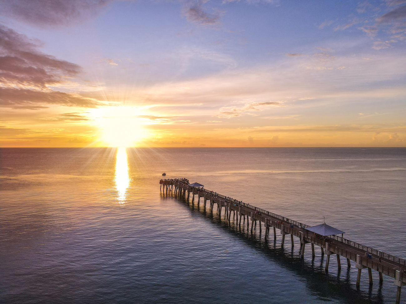 A drone shot of the Juno Beach Pier at sunrise.