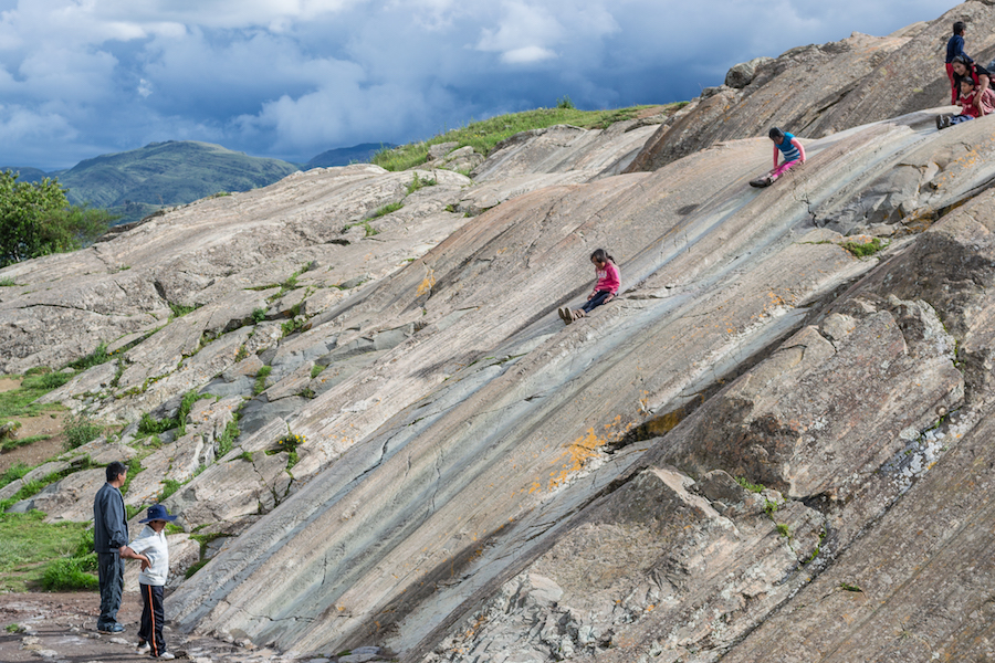 Children playing on the rock slides at Sacsayhuaman.