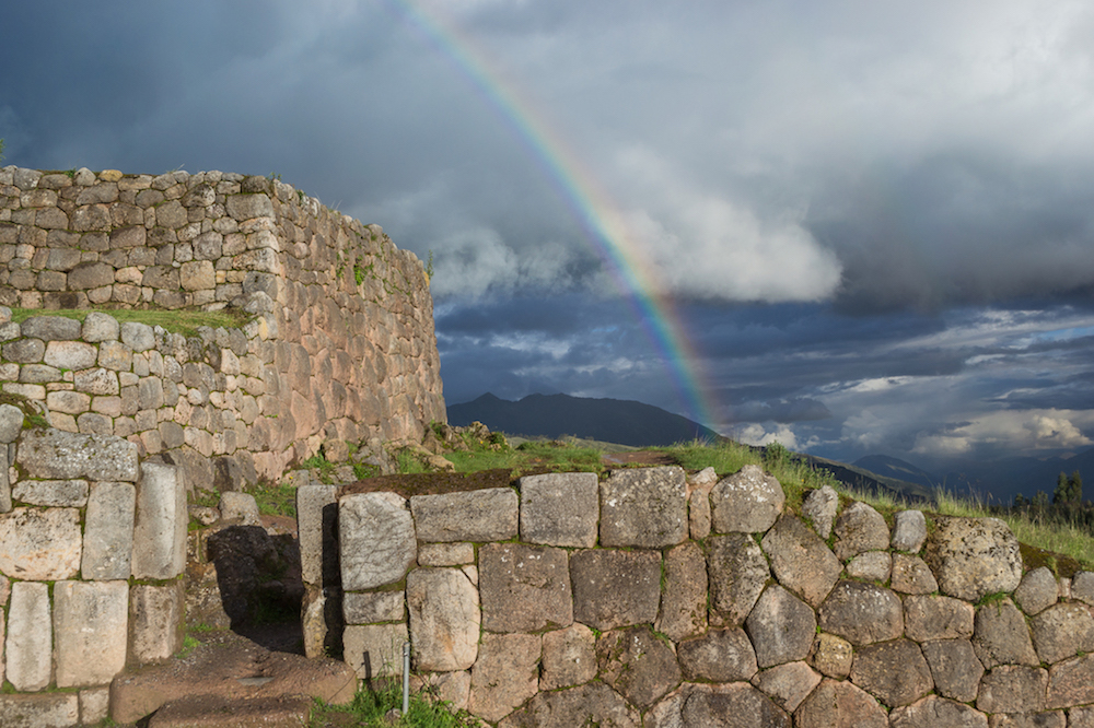 Exploring Cusco ruins--a rainbow over stone ruins at Puka Pukara.