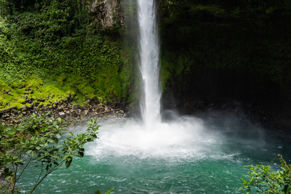 The La Fortuna Waterfall surrounded by rocks and green moss.