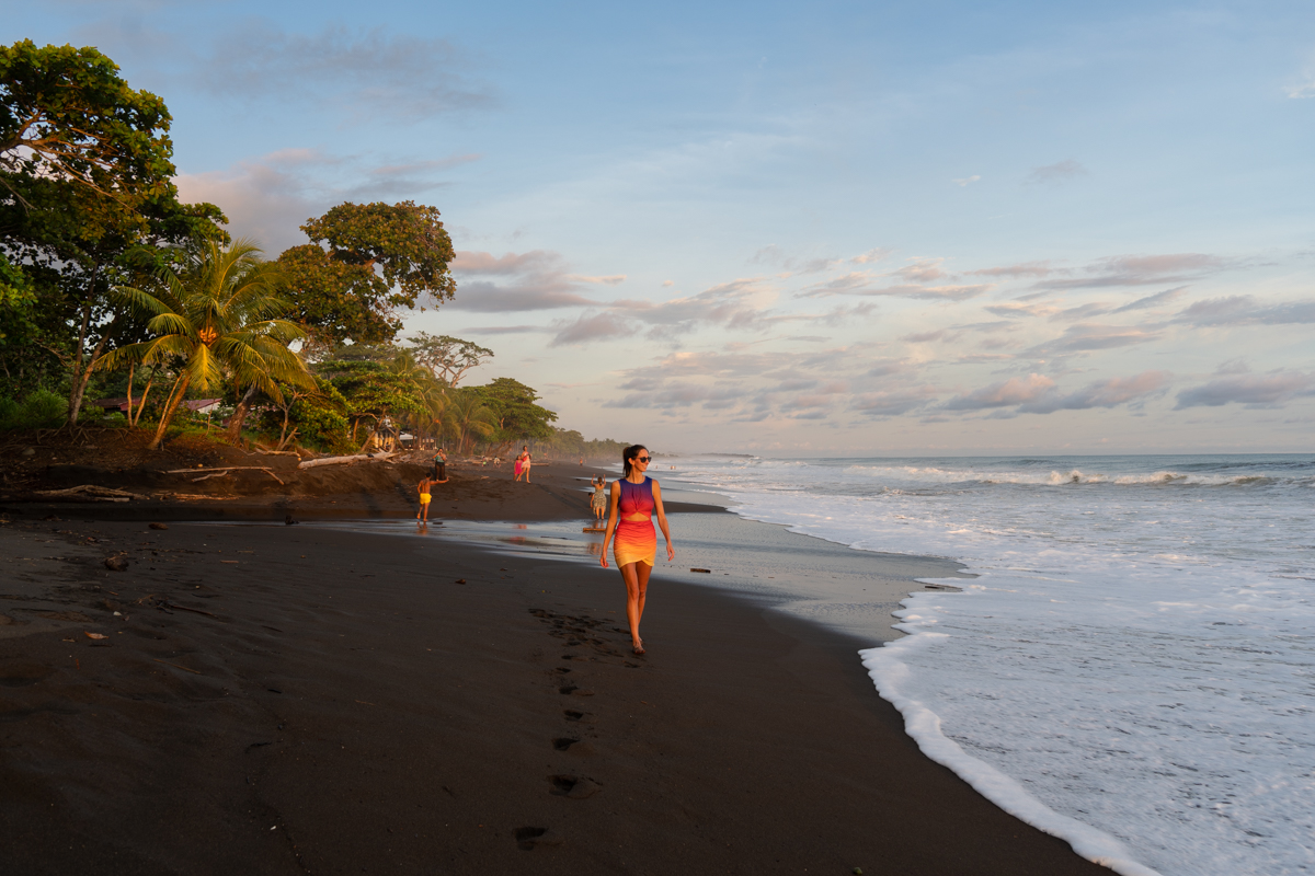 Walking the black sand beach of Playa Hermosa Puntarenas at sunset. 