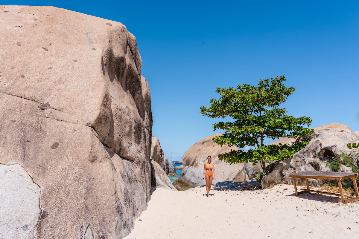 Standing next to a large beach boulder in the BVI.