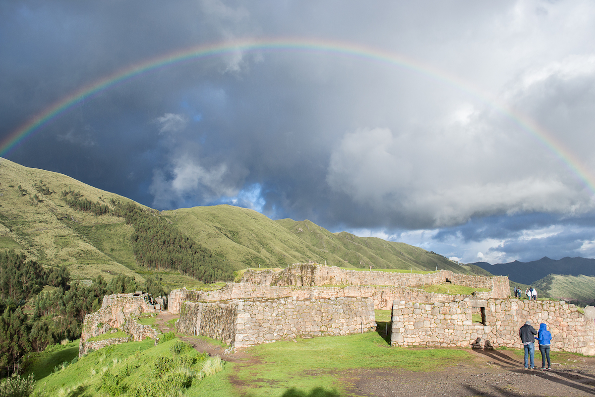 The ruins at Puka Pukara in Cusco, Peru with a rainbow over the ruins.