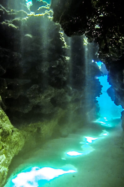 The light beams at Devil's Grotto while scuba diving in Grand Cayman through the tunnels.