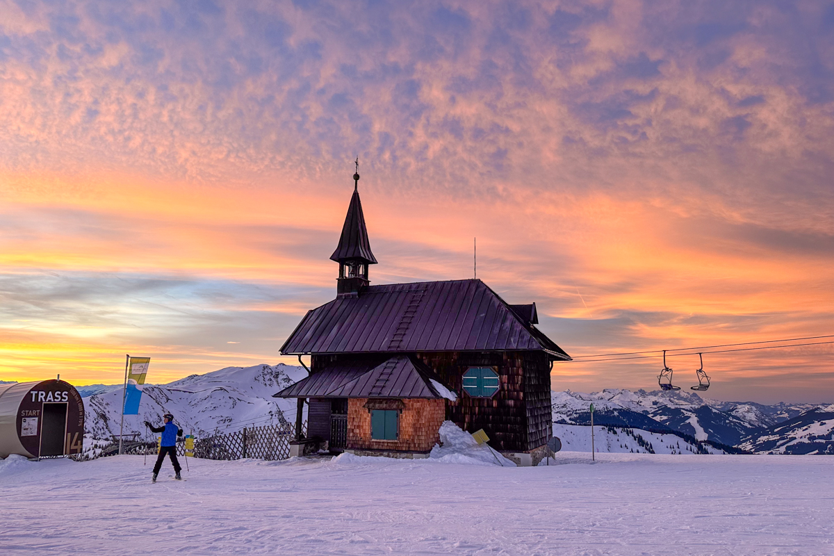 Skiing in Zell Am See at sunset near the little chapel on the mountain.