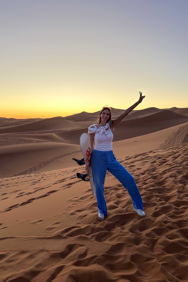 Sandboarding in the Sahara Desert at sunset.