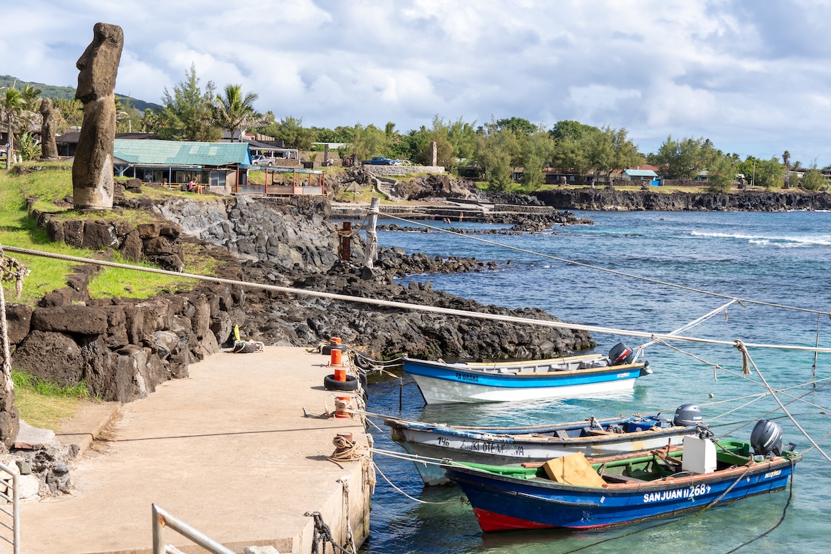Rapa Nui town and a Moai statue by the sea.